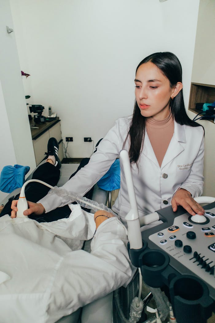 Services Female doctor conducting an ultrasound exam in a clinical setting.
